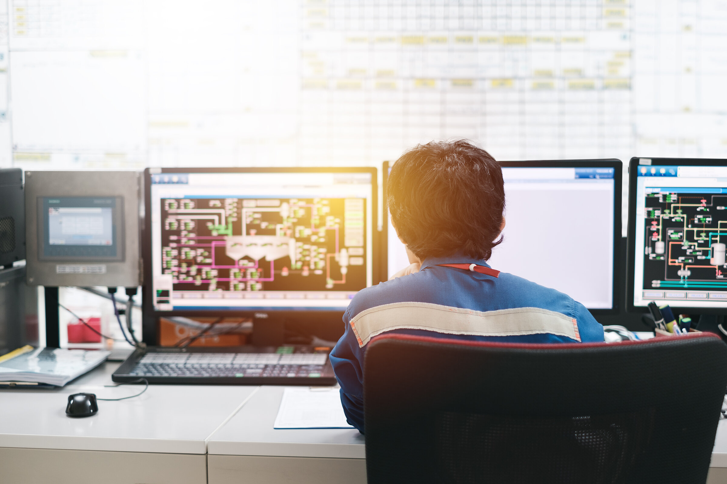 Professional technician sitting in control room monitoring proce