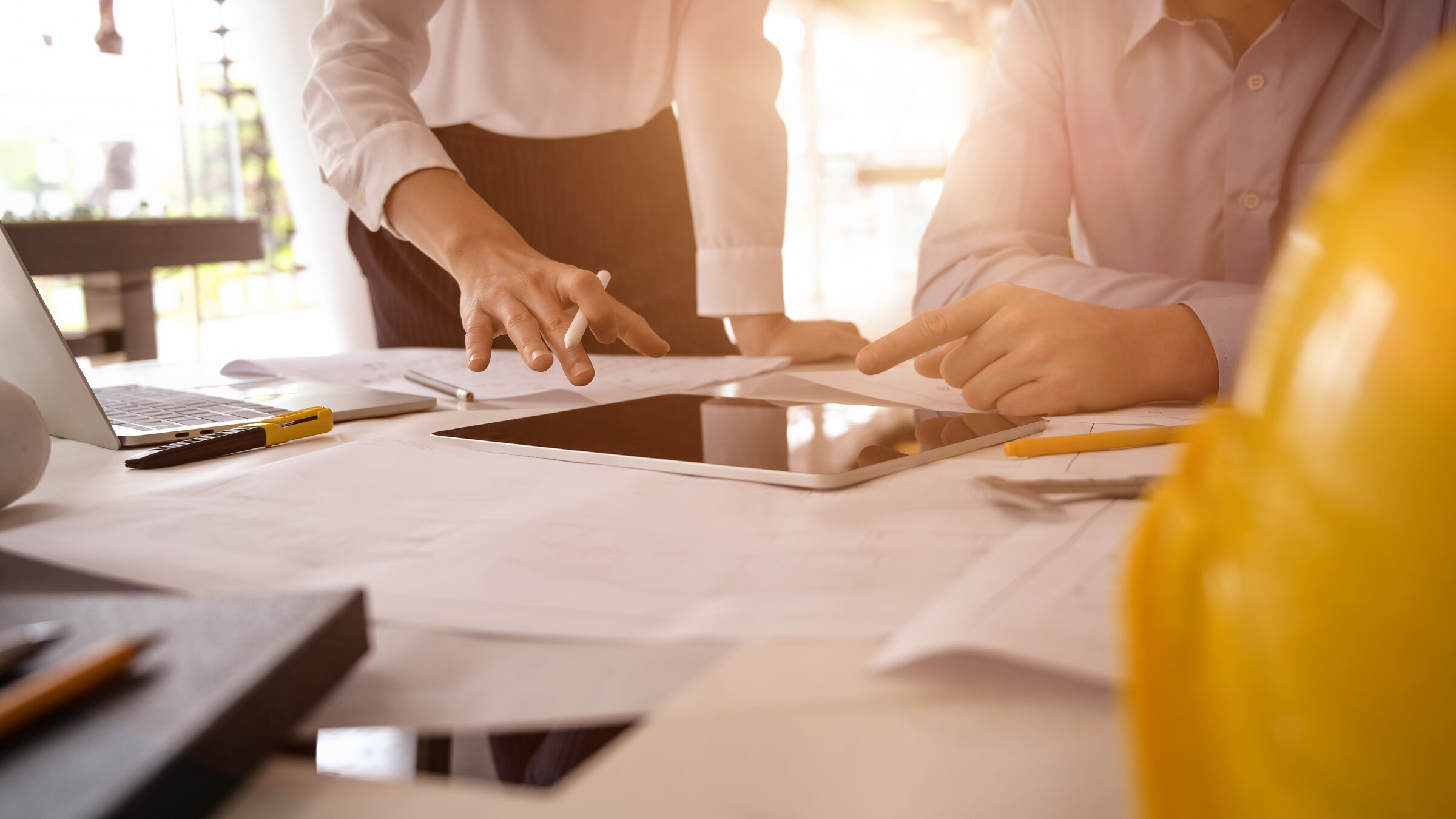 Architect designers discuss the sketches blueprint at working construction site