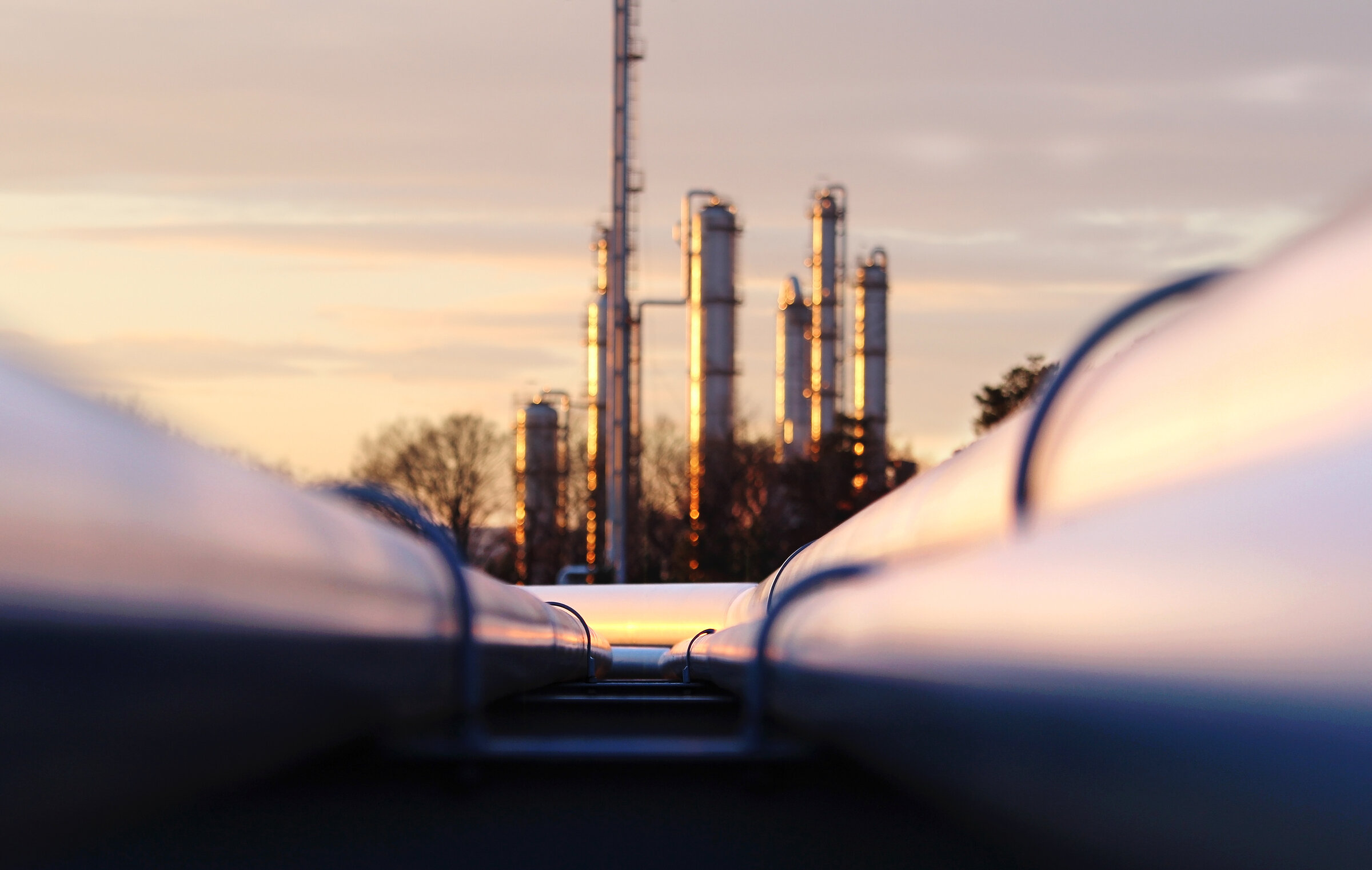 sunset at crude oil refinery with pipeline network